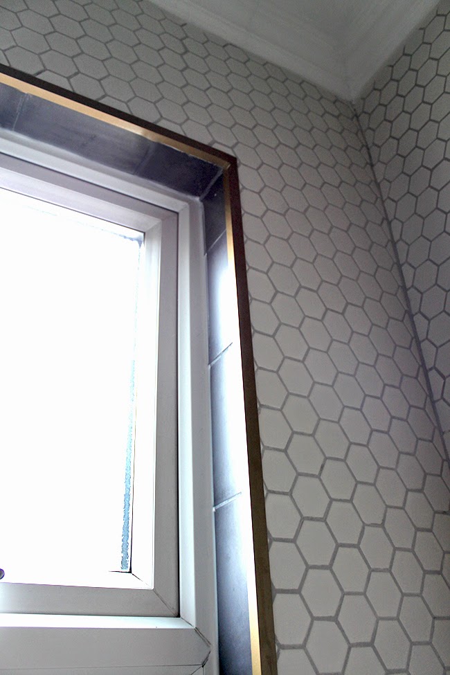 Around the window sill we used a steel corner bracket painted gold to match the shower rail. 