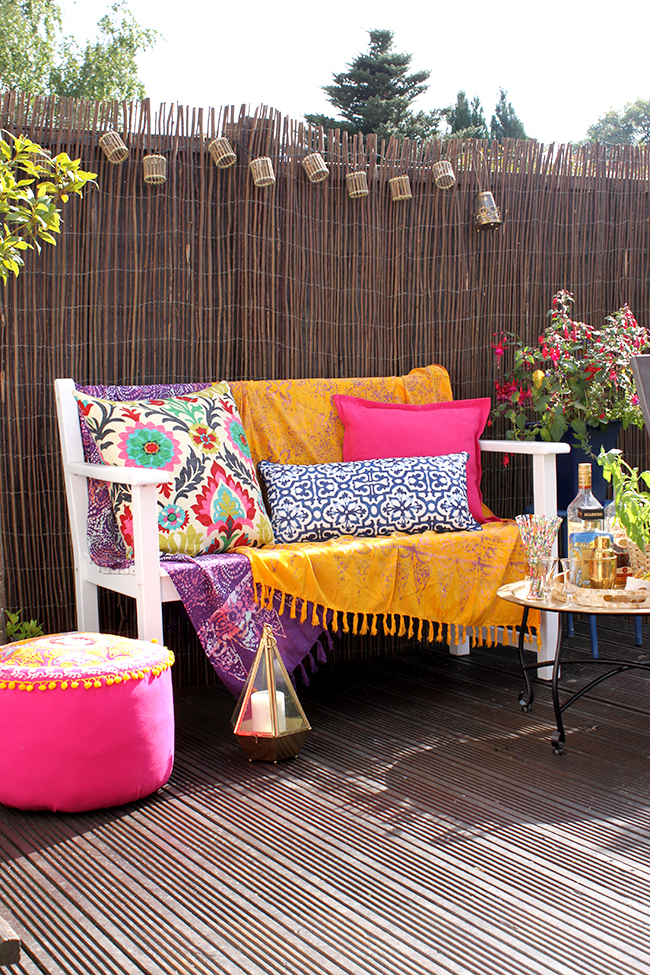 Eclectic Boho Glam Garden Reveal - Swoon Worthy - Boho textiles on white bench