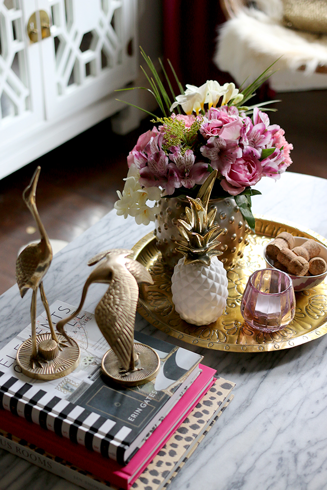coffee table styling - brass cranes, marble coffee table, pink flowers, white and gold pineapple, brass tray, pink candle