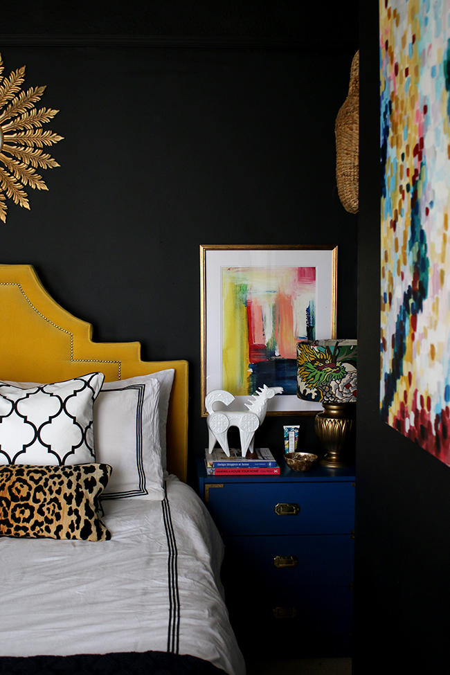 black bedroom with colourful accents, yellow headboard, sunburst mirror - see more on www.swoonworthy.co.uk
