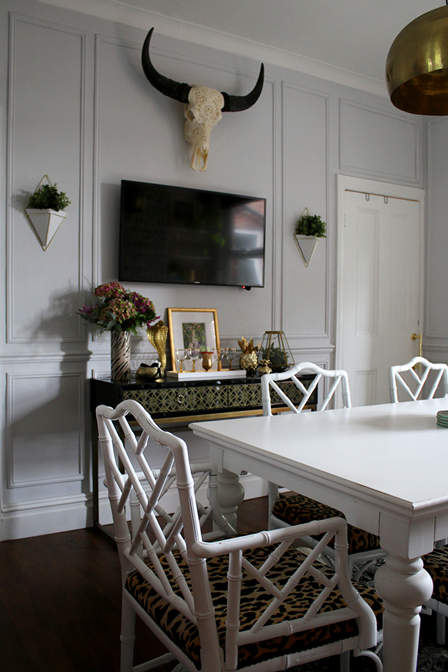 wall paneling, black console table with TV, wall planters, skull - see more on www.swoonworthy.co.uk