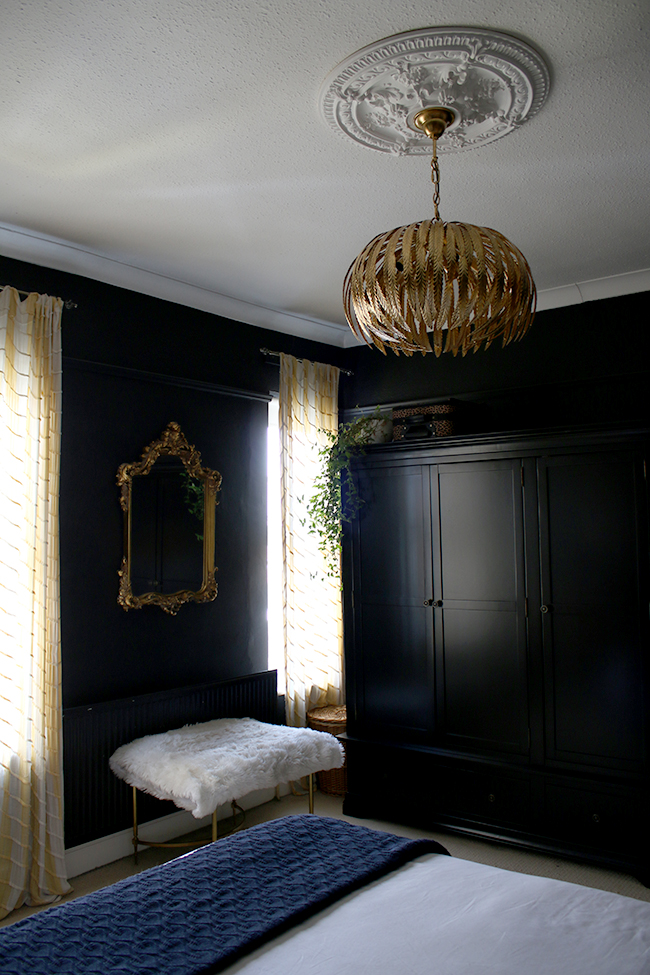 black bedroom wardrobes with gold light fixture and ornate gold mirror - see more on www.swoonworthy.co.uk