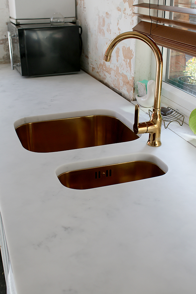 Minerva cararra acrylic worktops with gold sink and tap