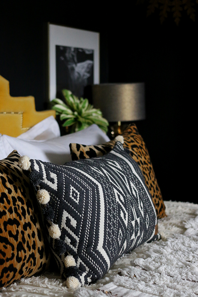 Boho glam bedroom with leopard print cushions and Moroccan wedding blanket