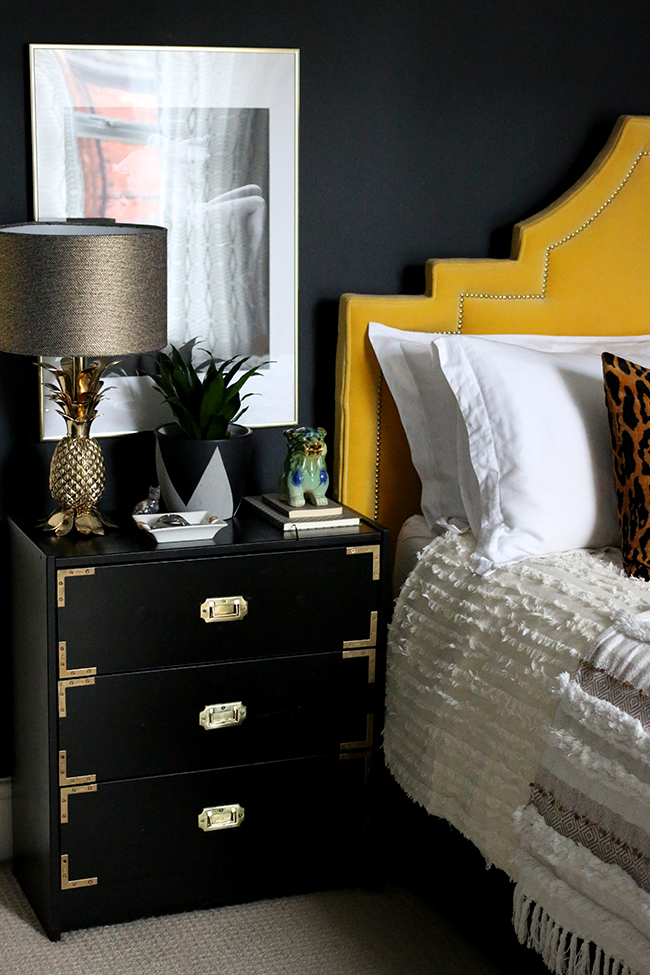 black campaign style nightstand with gold pineapple lamp
