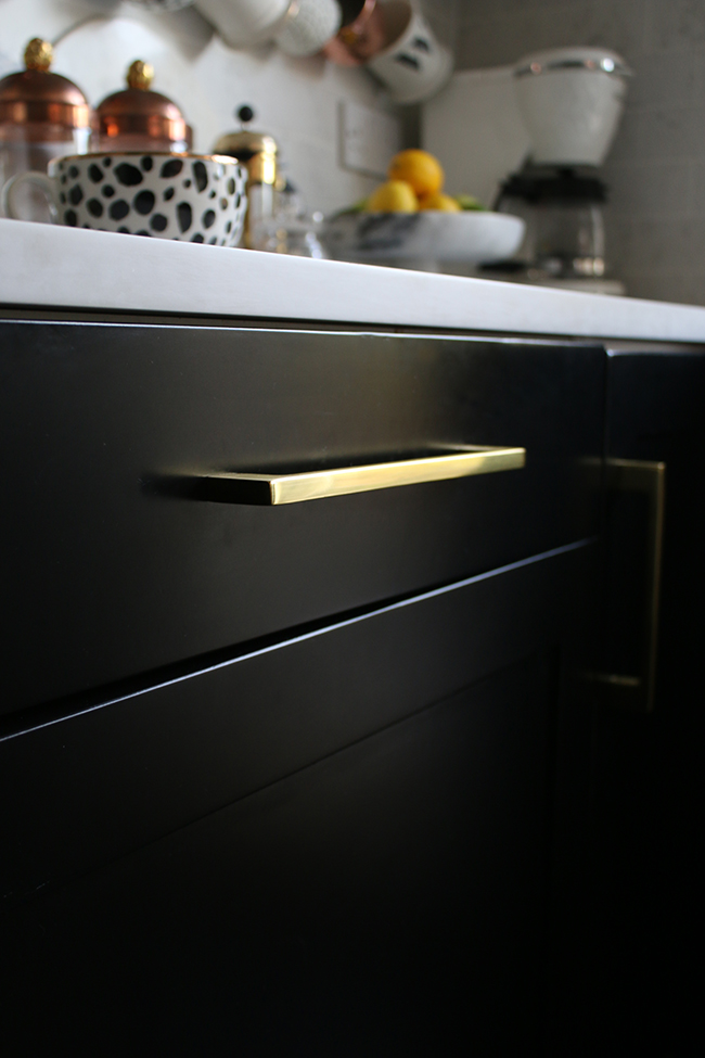 black kitchen cabinets with gold pull handles