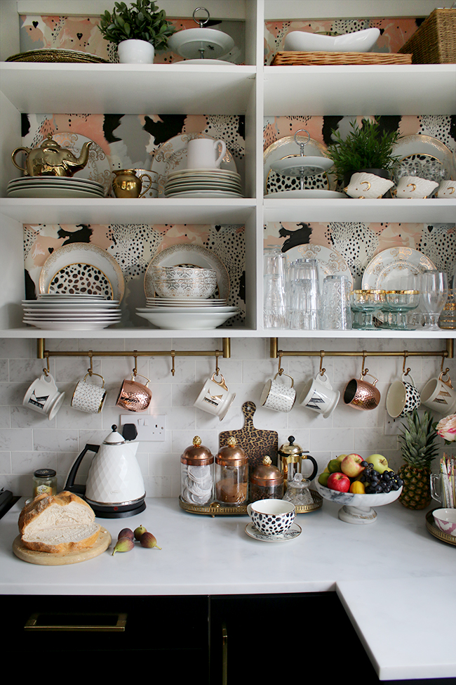 open shelving in kitchen with gold accents and hanging mugs
