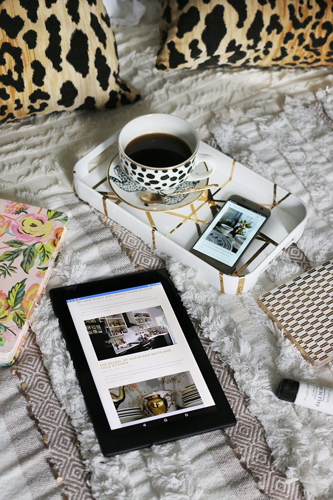 flatlay with tablet and mobile on bed with cup of coffee and leopard print neutrals texture