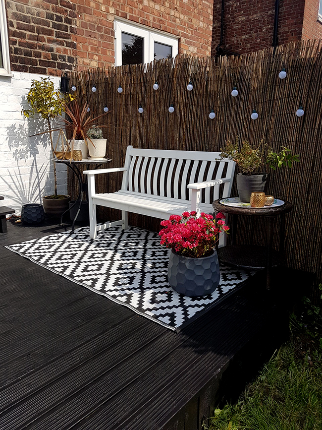 black deck with white bench and festoon lighting