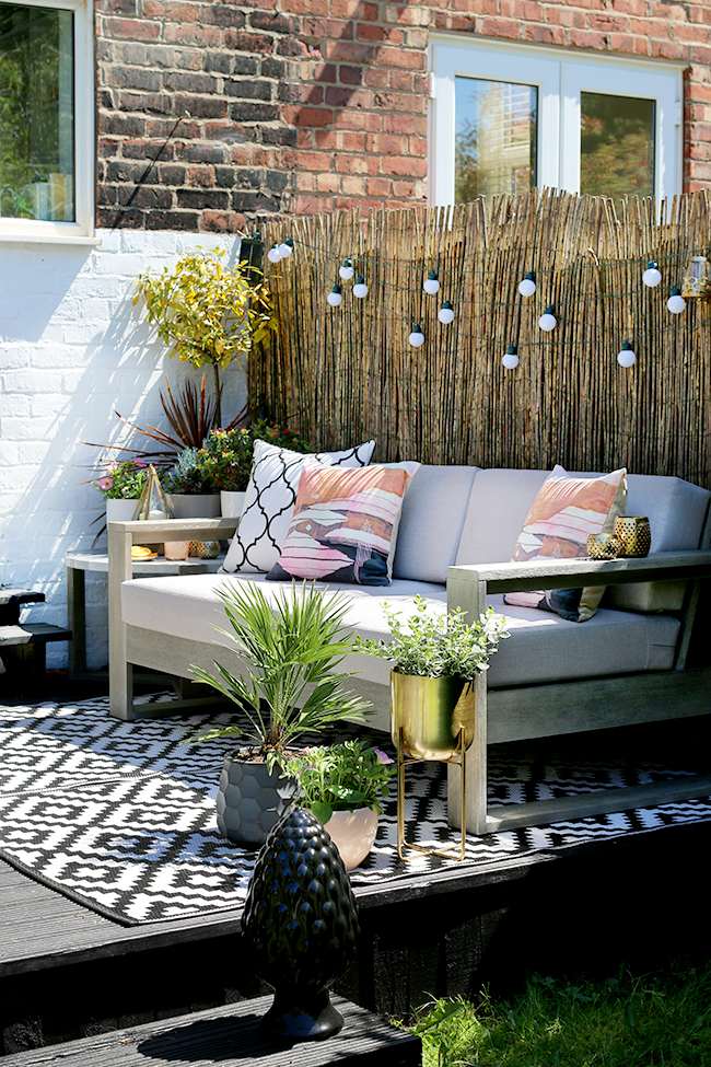garden patio design with grey sofa and gold accents