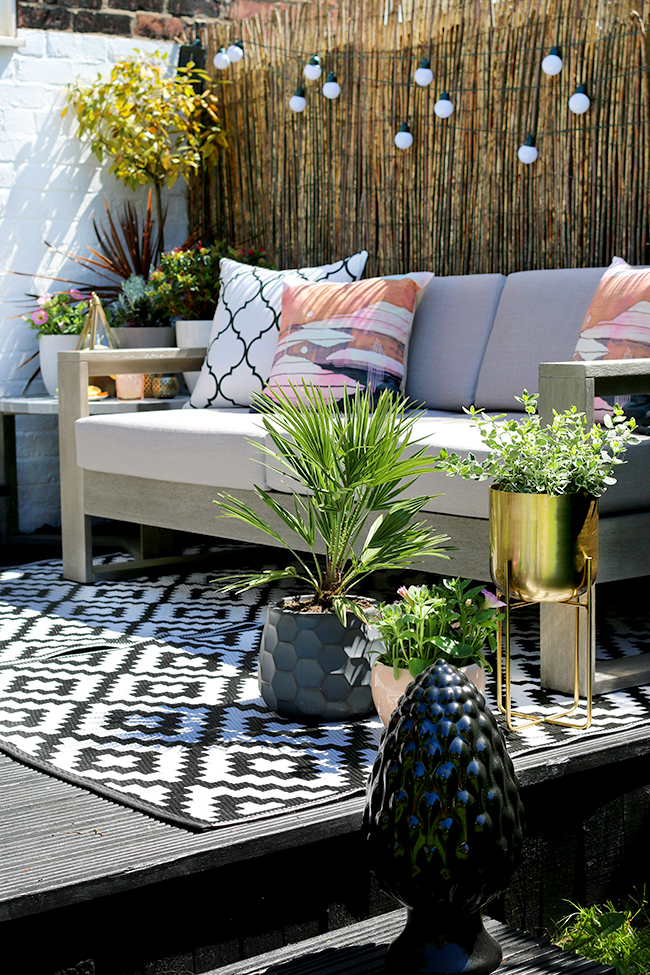 outdoor garden design patio with grey sofa 