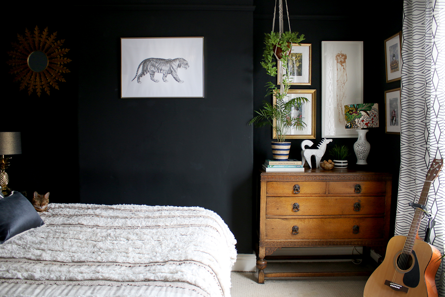 black boho glam bedroom with vintage dresser and plants