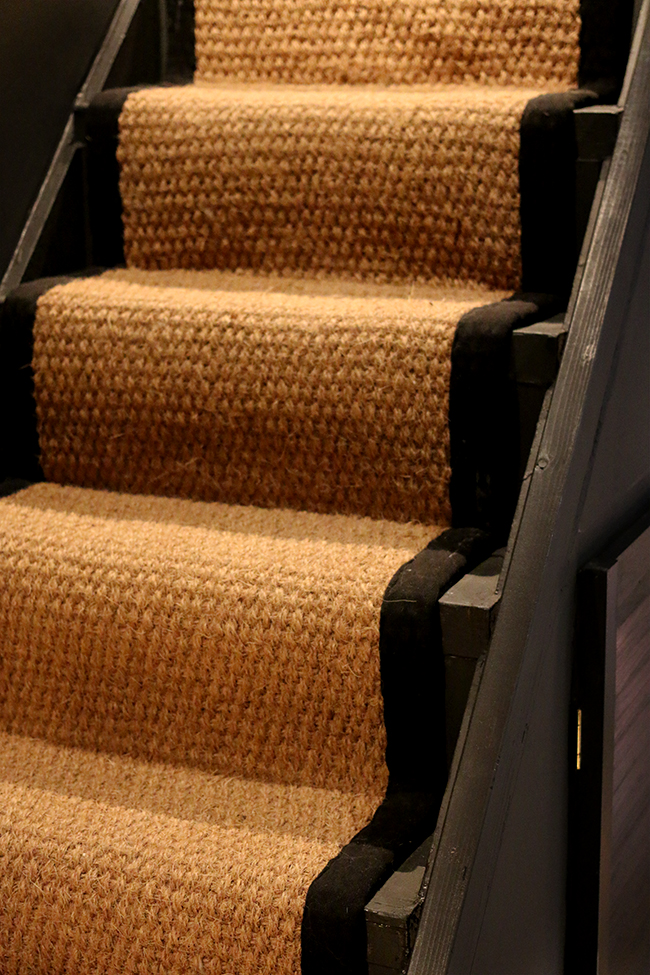 black stairs with coir runner