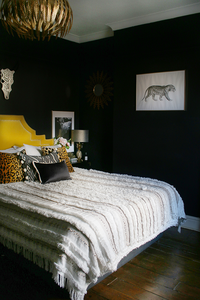 black bedroom with gold headboard boho glam