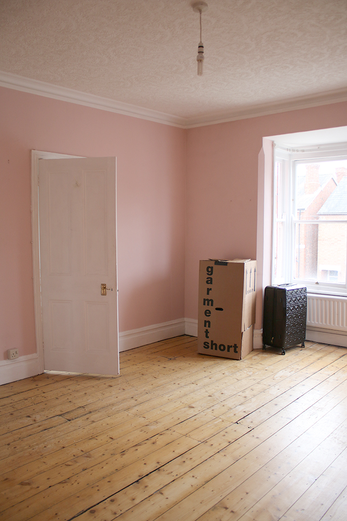 empty pink room in Victorian house with stripped floorboards