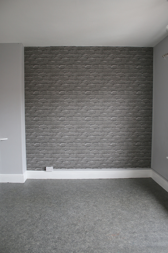 Grey bedroom with faux brick feature wall