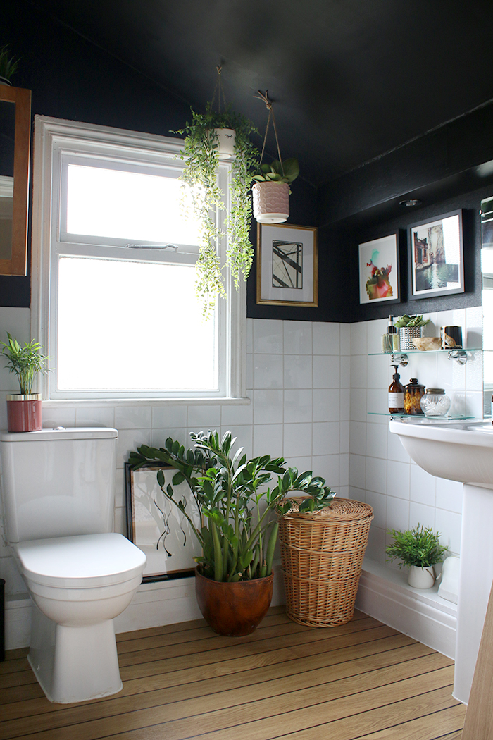 Boho glam black bathroom with plants, wood and gold accents