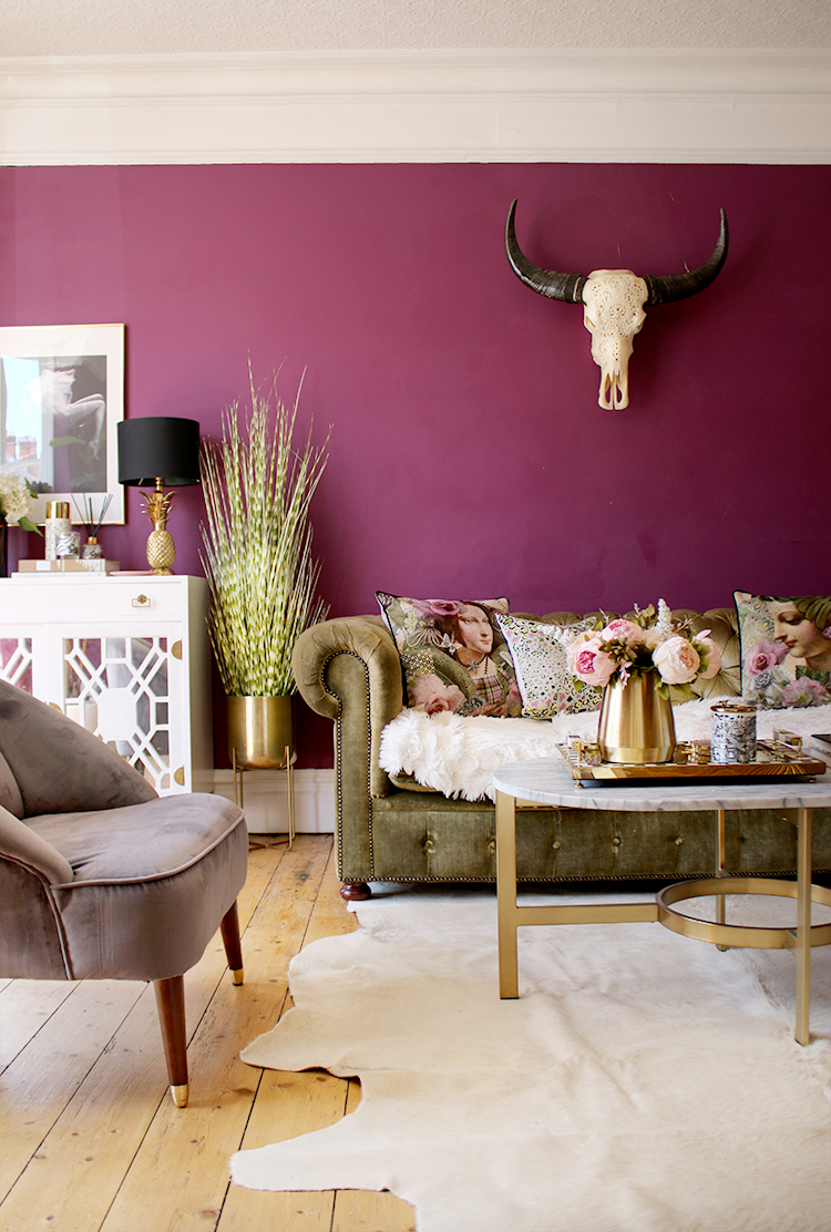 plum living room with gold accents and olive green velvet sofa