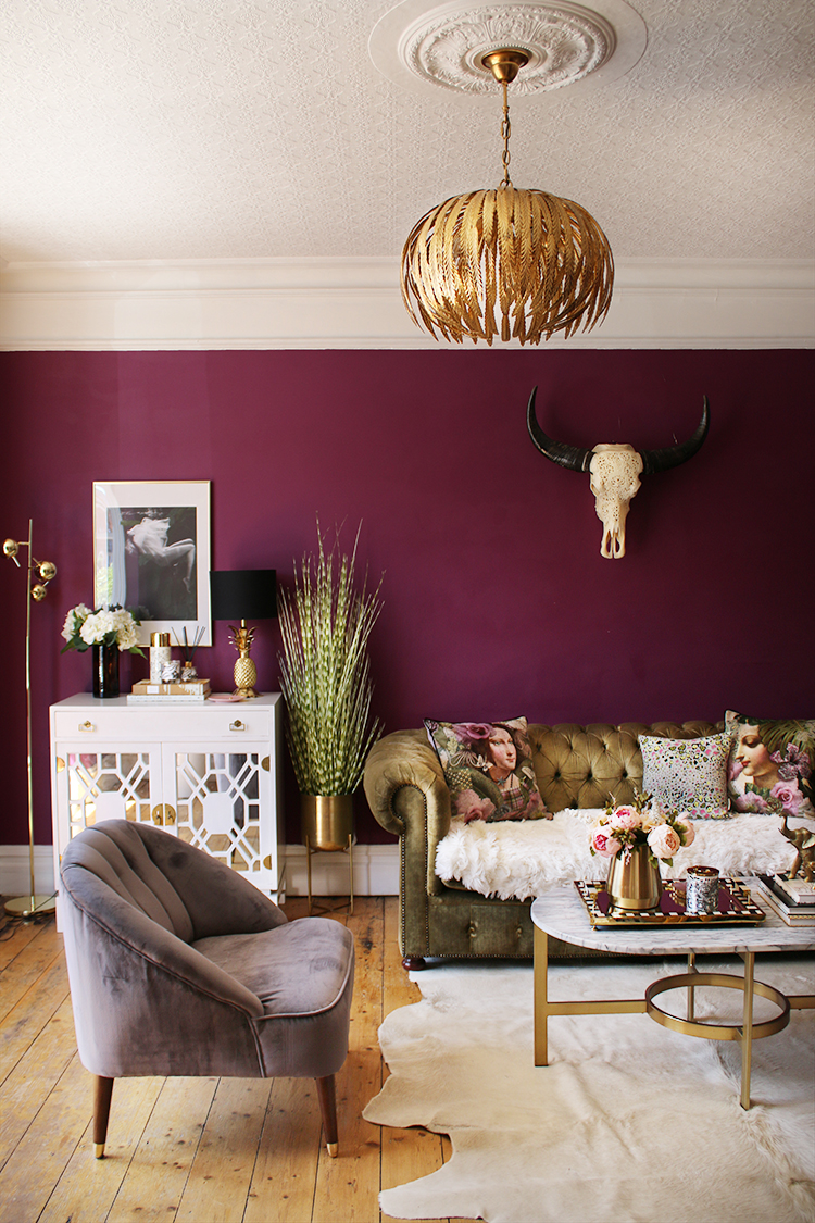plum living room with gold accents and olive green velvet sofa