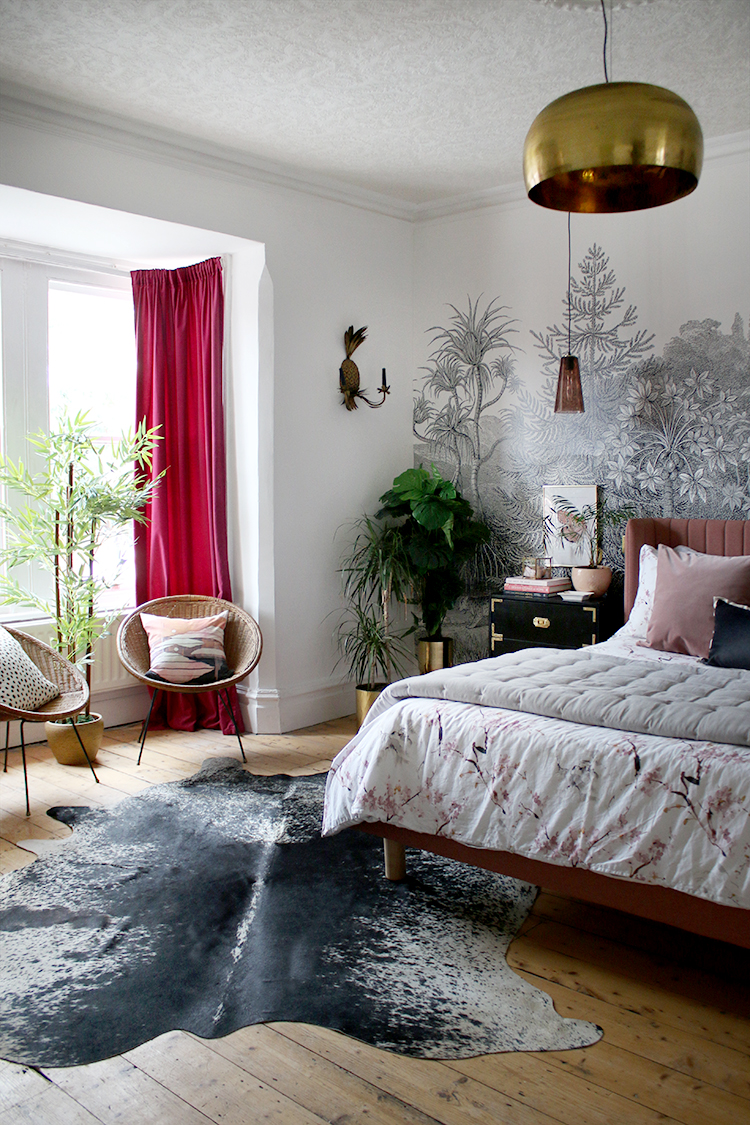 jungle glam bedroom with wall mural and cow hide rug in pink black and gold