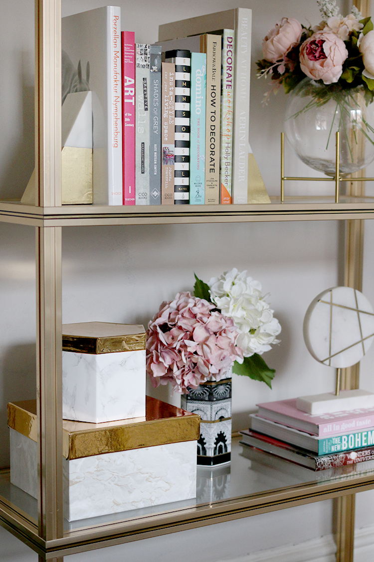 styled gold shelving unit with marble gold and pink accessories