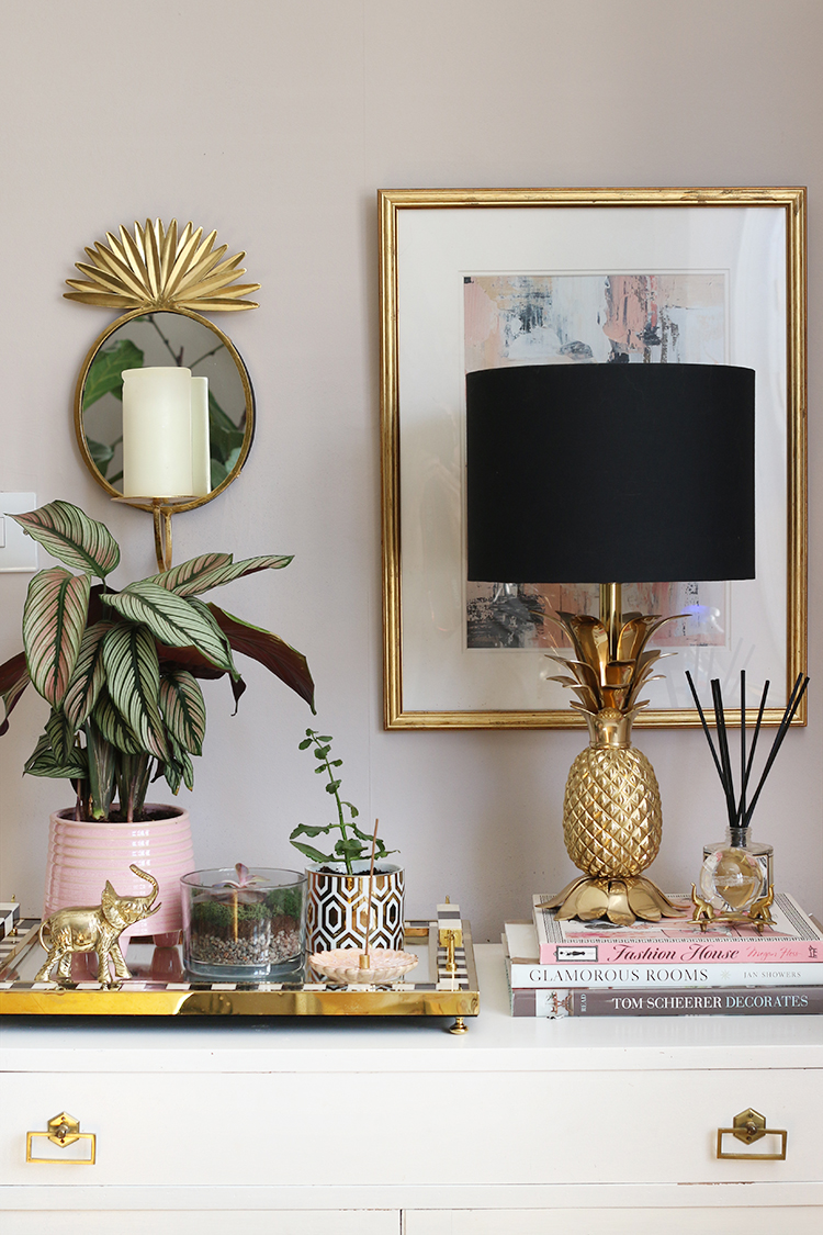 Styled vignette in living room with candle jars as small plant pots