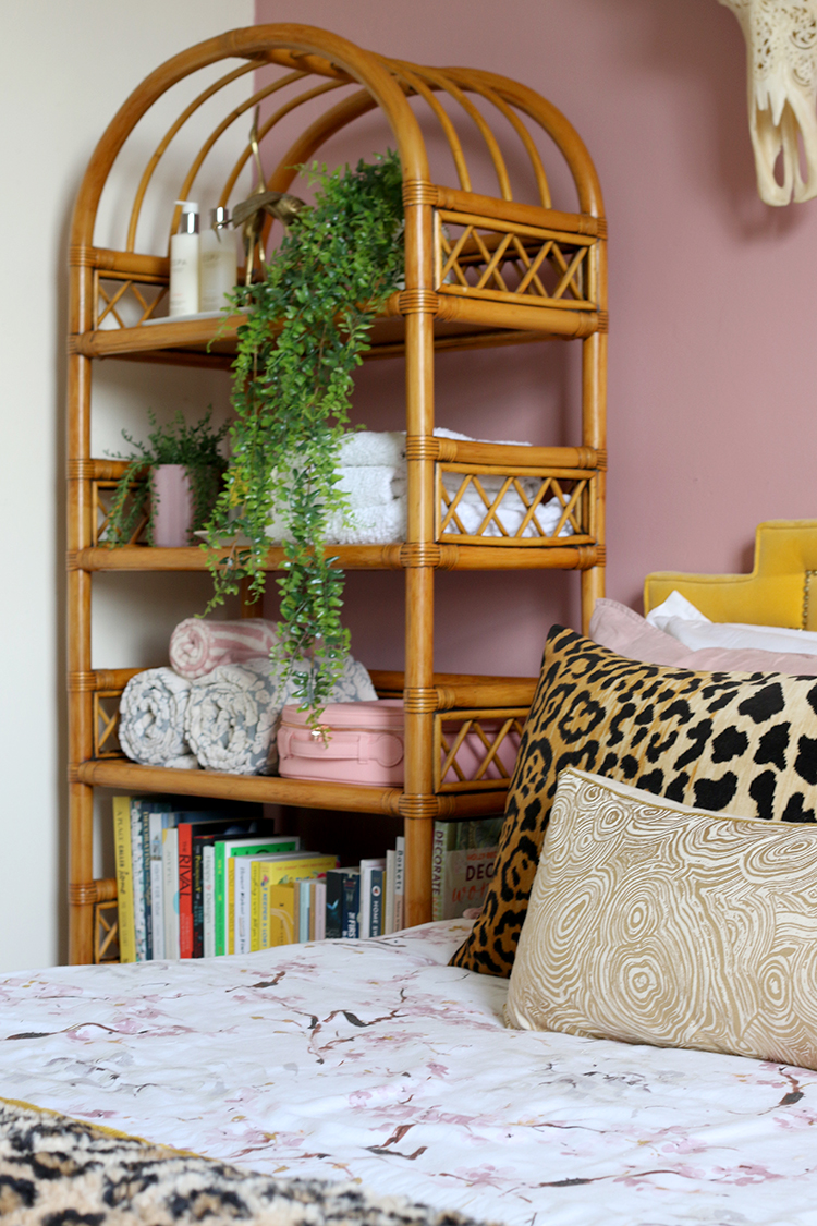 pink bedroom with vintage rattan shelving unit