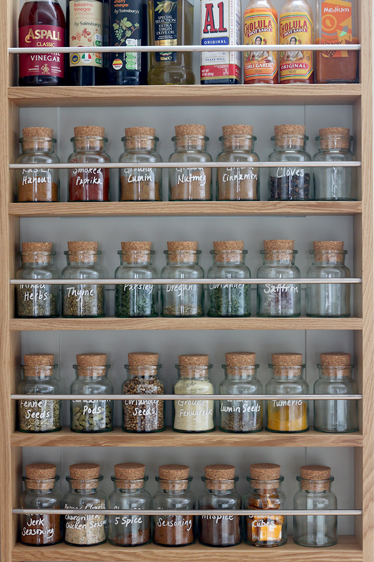 spice rack with cork topped bottles labelled with white paint pen