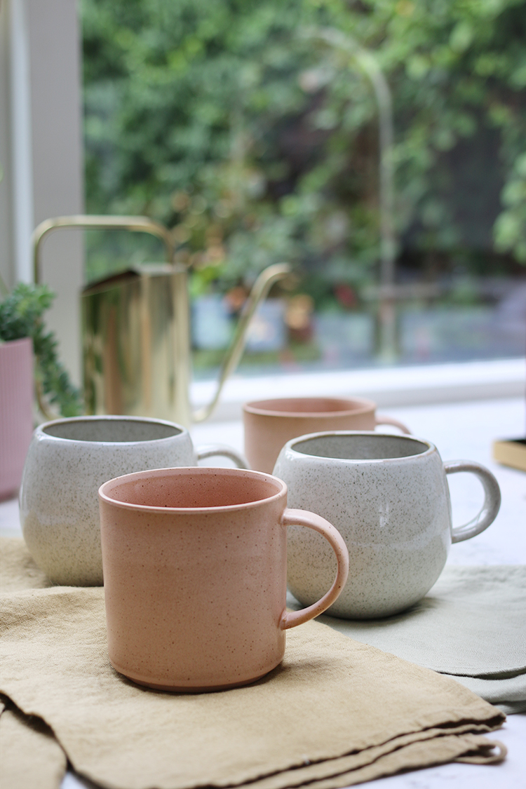 peach and cream mugs from Rose & Grey on linen towels in kitchen