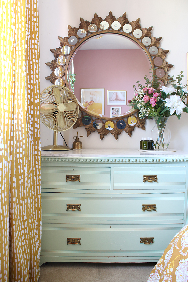 mint green chest of drawers with starburst mirror above